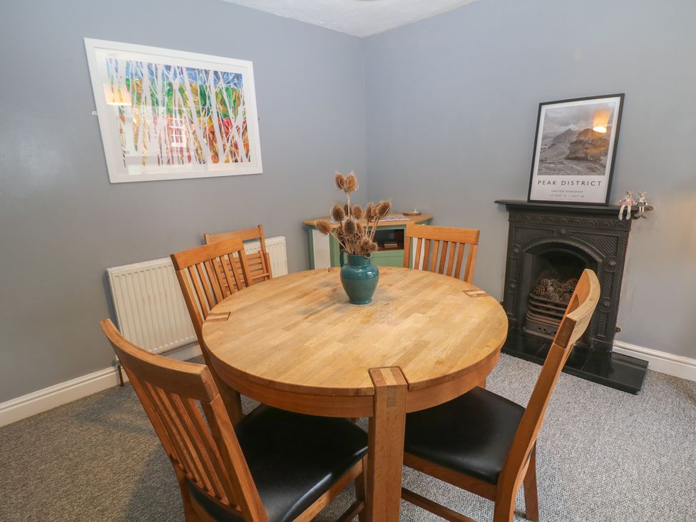 A dining room with a round table and chairs at East Bank Cottage in Winster