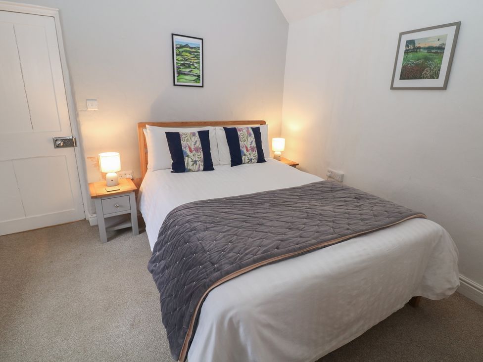 A bedroom with a bed and bedside tables at East Bank Cottage in Winster