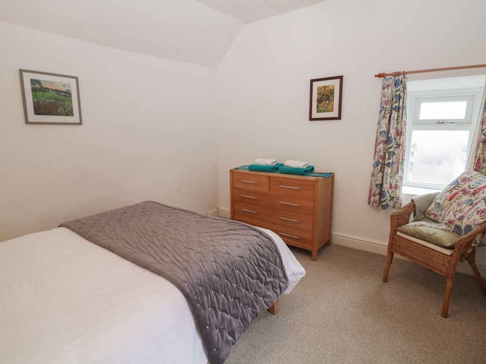 A bedroom with a bed and dresser at East Bank Cottage in Winster