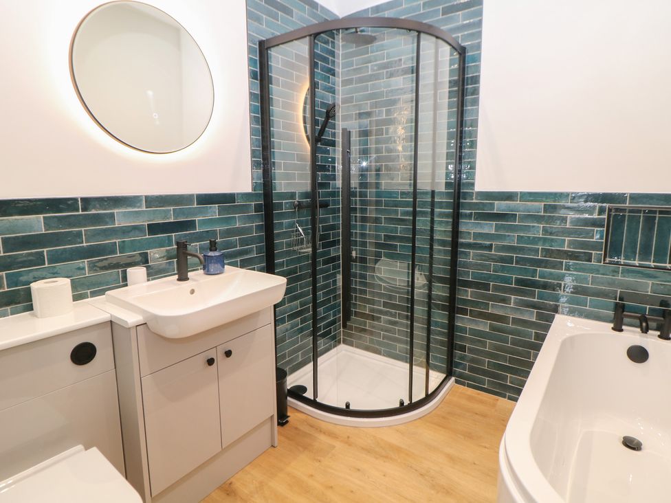 A bathroom with a shower, toilet, and sink at East Bank Cottage in Winster