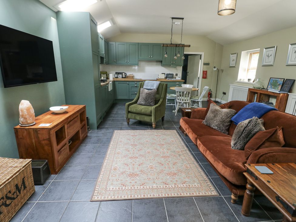 A living room with a kitchen area and seating arrangement at The Old Tannery Beaumaris