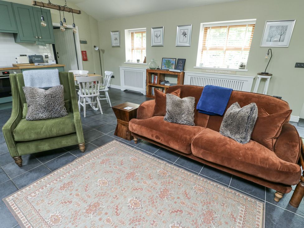 A living room with a sofa and armchair at The Old Tannery Beaumaris