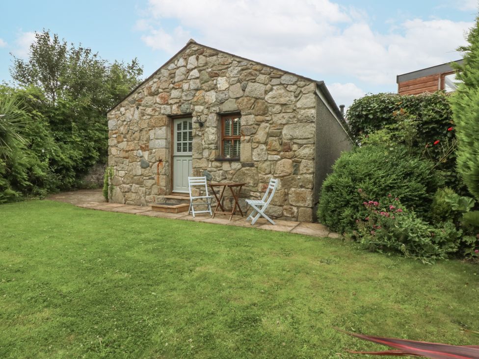 A stone building with a patio and outdoor furniture at The Old Tannery in Beaumaris