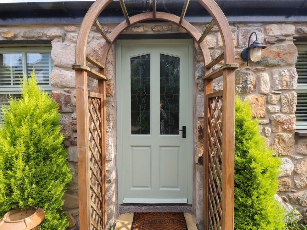 A door with an archway and plants at The Old Tannery in Beaumaris