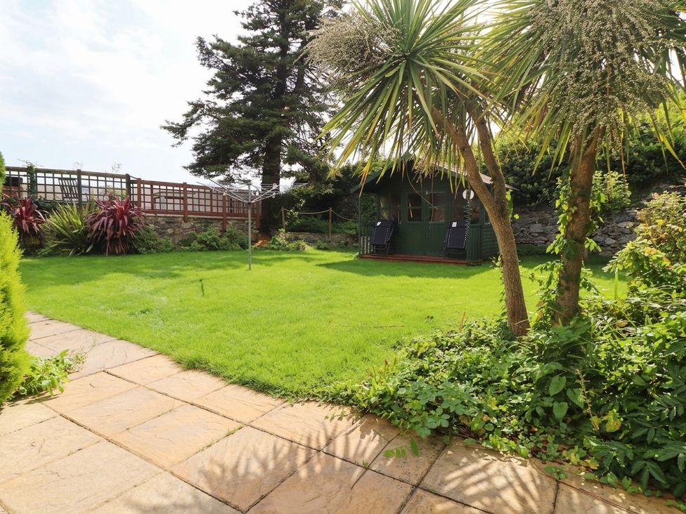 A garden with grass, trees, and a shed at The Old Tannery in Beaumaris