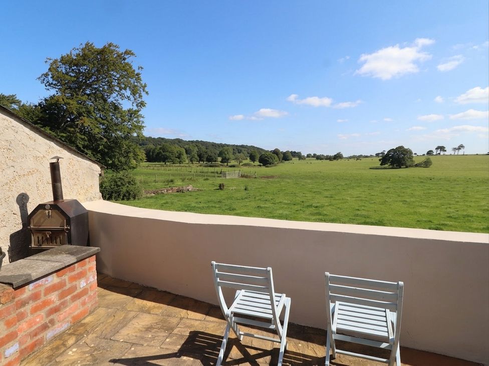 An outdoor area with chairs and barbecue overlooking a field at The Old Tannery Beaumaris