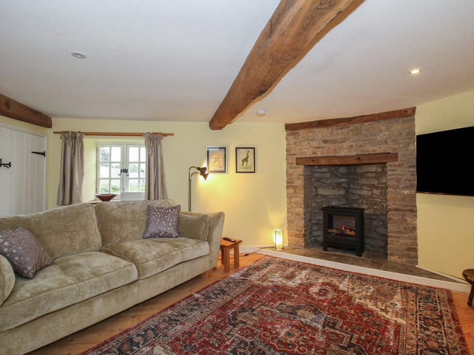 A living room with a fireplace and sofa at Malt House