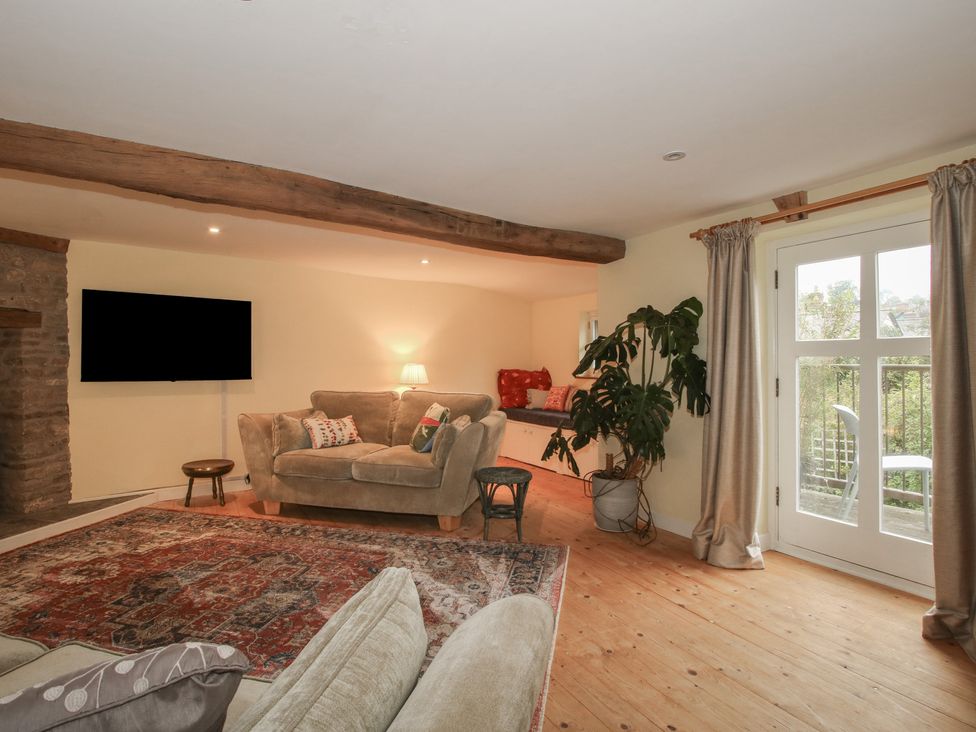 A living room with a sofa and television at Malt House in 