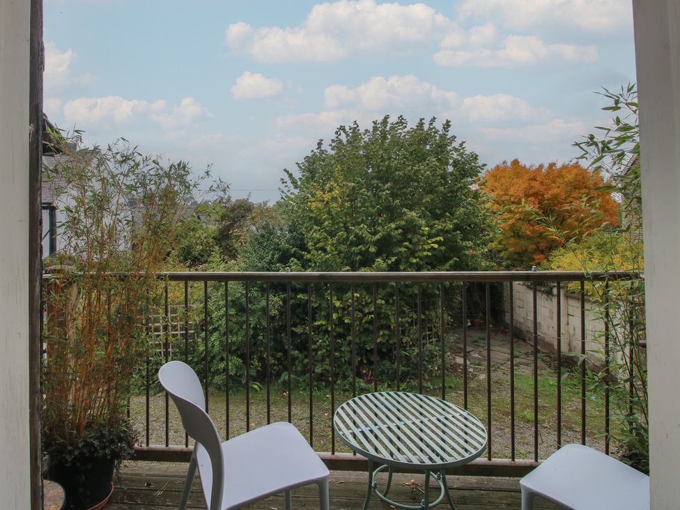 A balcony with a table and chairs overlooking greenery at Malt House