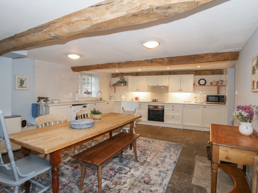 A kitchen with cabinets and dining table at Malt House