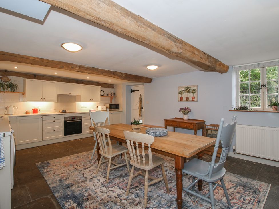 A kitchen with a wooden table and chairs at Malt House 