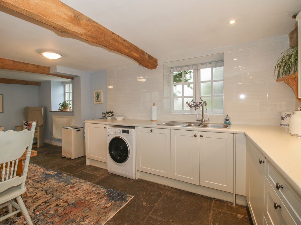 A kitchen with a washing machine and dining area at Malt House 