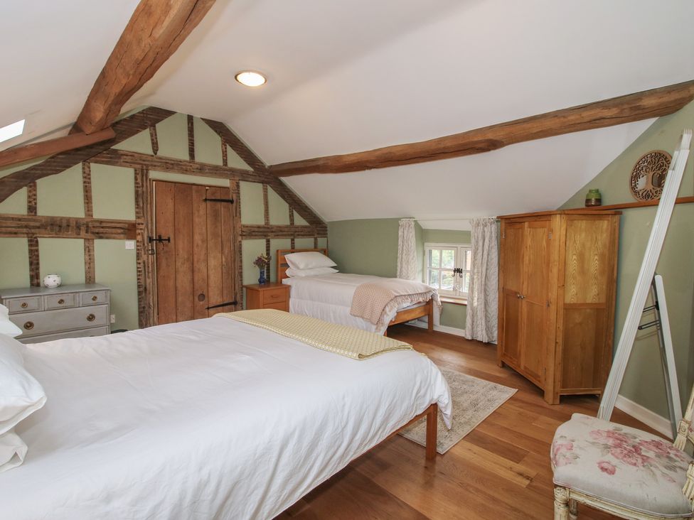 A bedroom with two beds and a wardrobe at Malt House