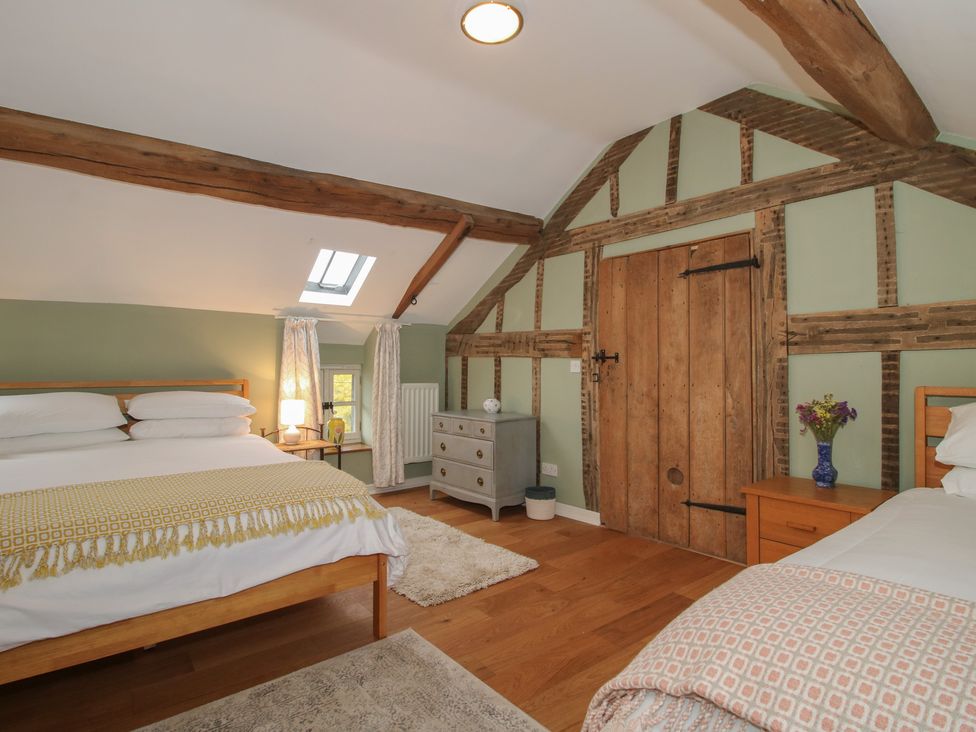 A bedroom with two beds and a wooden door at Malt House