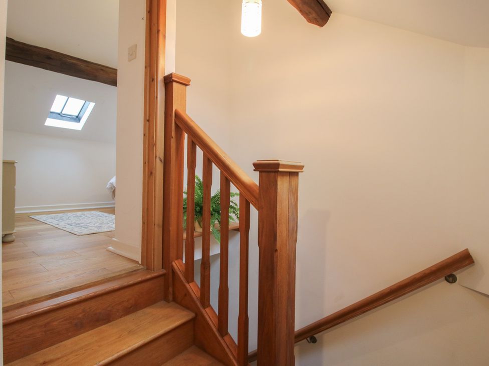 A staircase with wooden railing and light fixture at Malt House