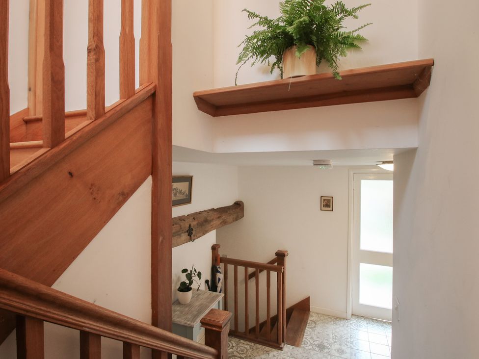 A staircase with a shelf and plant in a hallway at Malt House