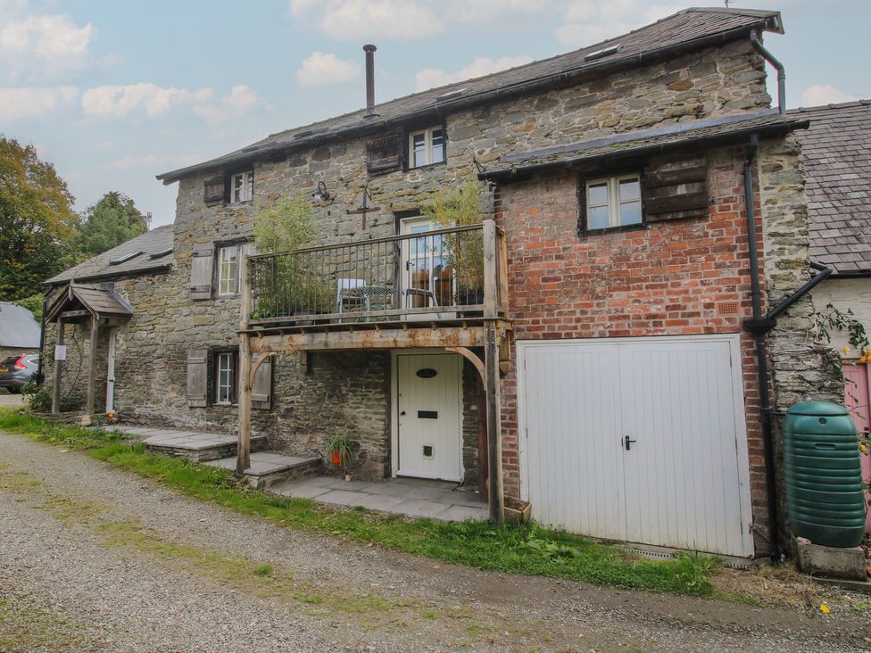 An outdoor view of a house with a balcony and driveway at Malt House in Bishop's Castle