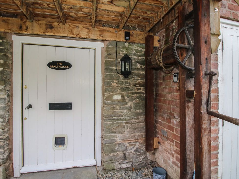 An entrance with a sign and pulley system at Malt House in Bishop's Castle