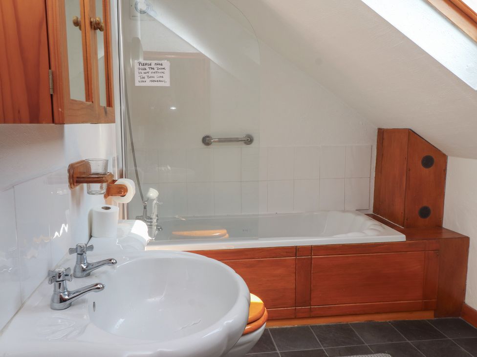 A bathroom with a bathtub and sink at Beech Tree Cottage Waunfawr