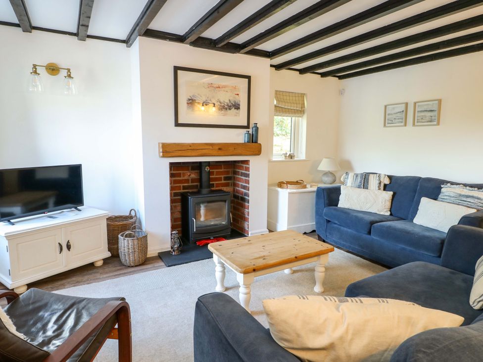 A living room with a fireplace and sofa at Craig Mawr in Benllech