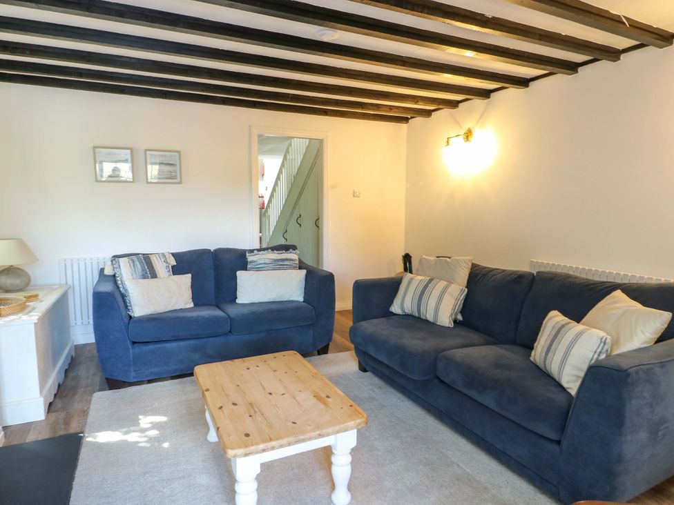 A living room with sofas and a table at Craig Mawr in Benllech