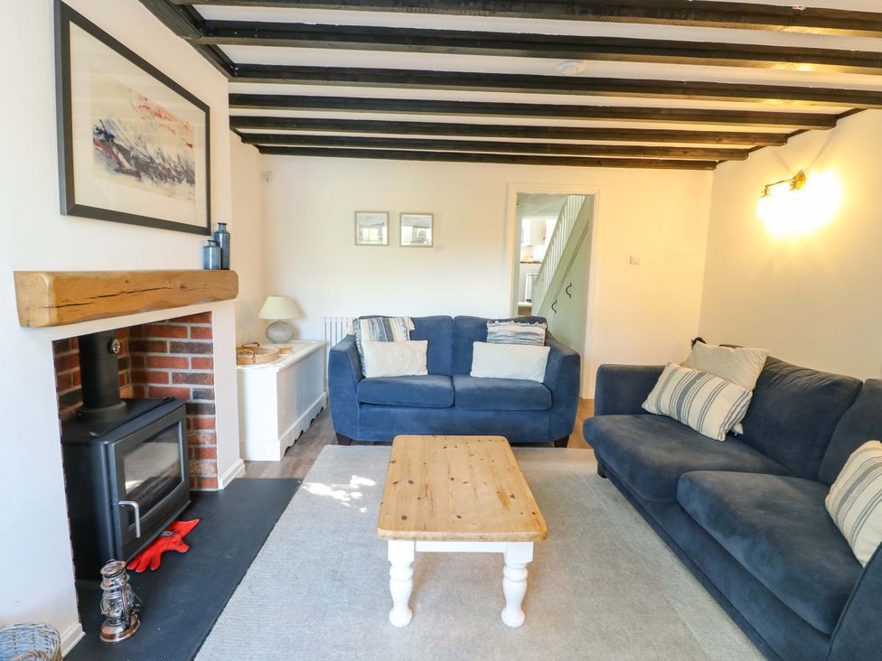 A living room with sofas and a fireplace at Craig Mawr in Benllech