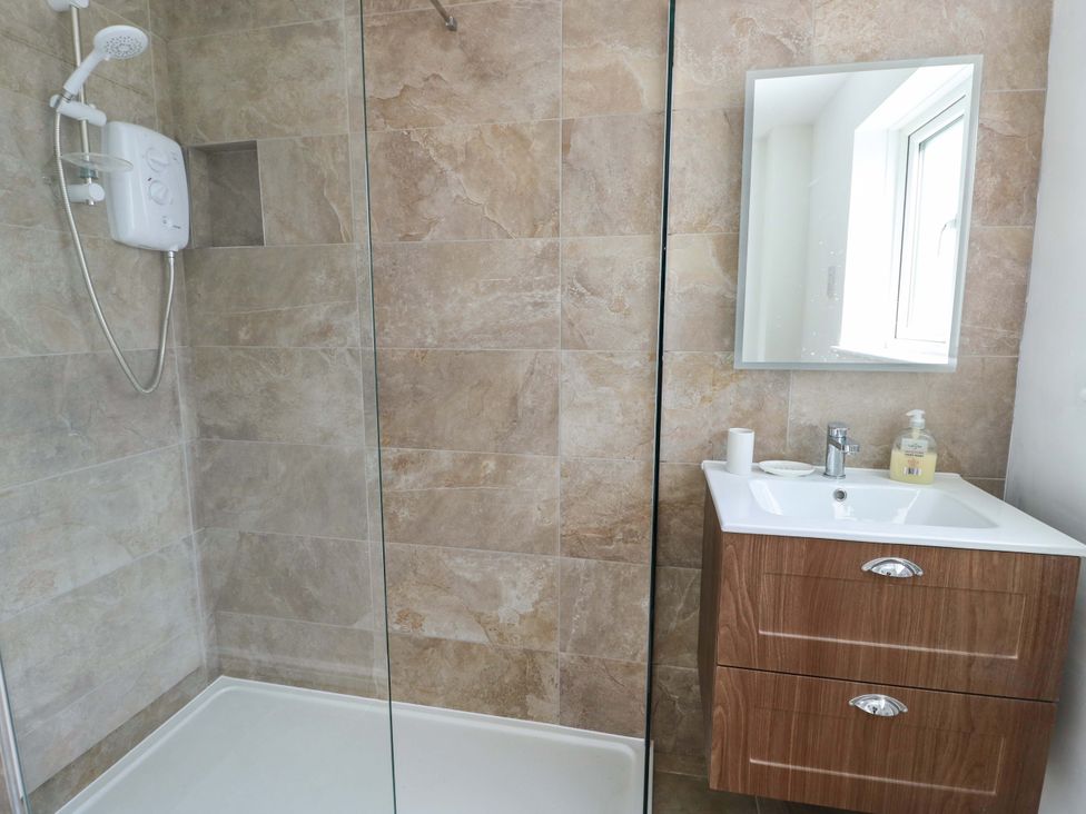 A bathroom with a shower and sink at Craig Mawr in Benllech