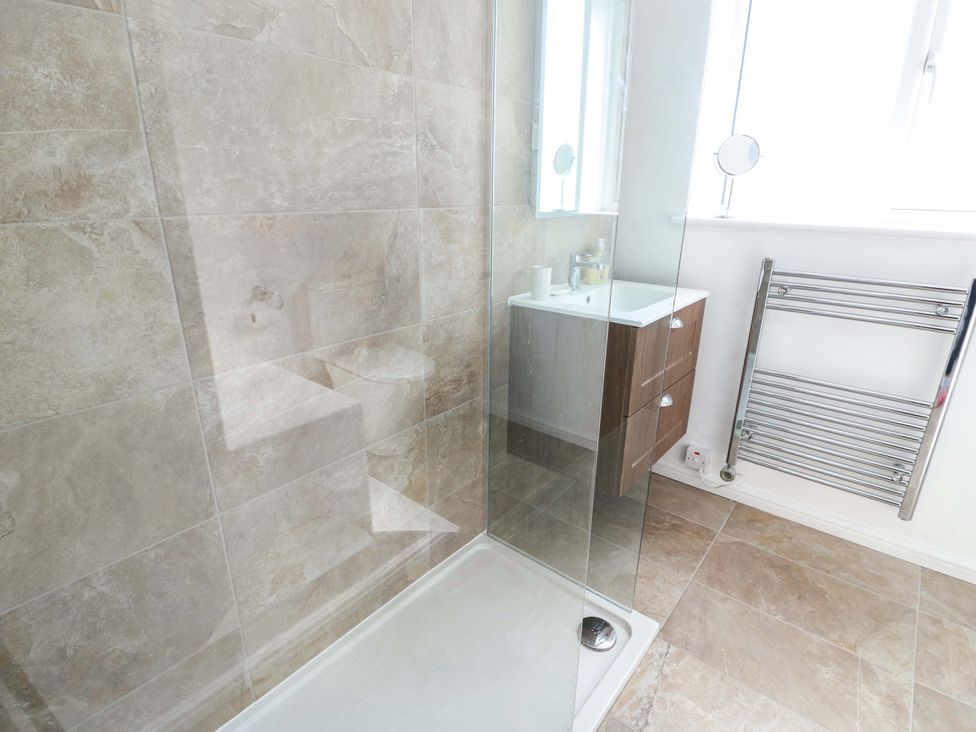 A bathroom with a shower and vanity unit at Craig Mawr in Benllech