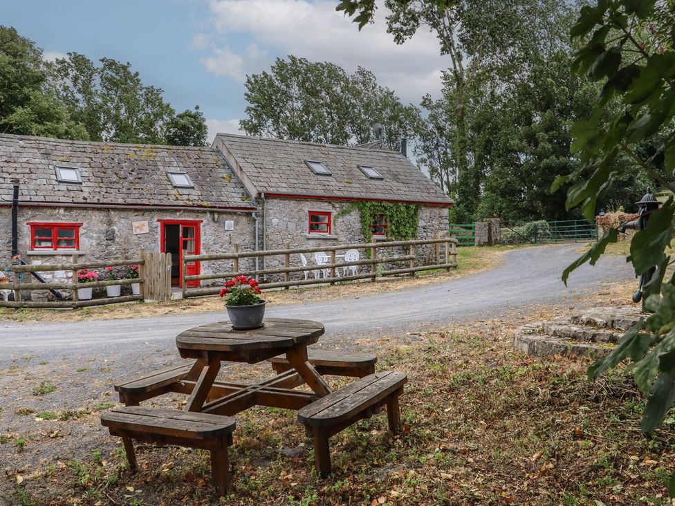 A cottage with a picnic table and flower pot at The Dairy in Ardfinnan, County Tipperary