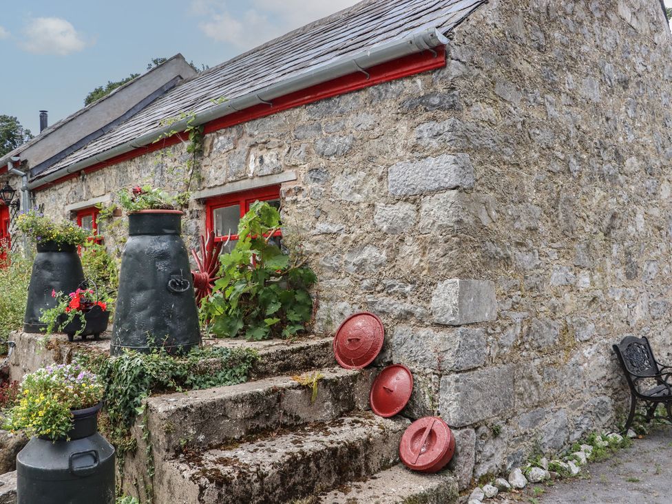 An outdoor area with stone steps and black and red pots at The Dairy in Ardfinnan, County Tipperary
