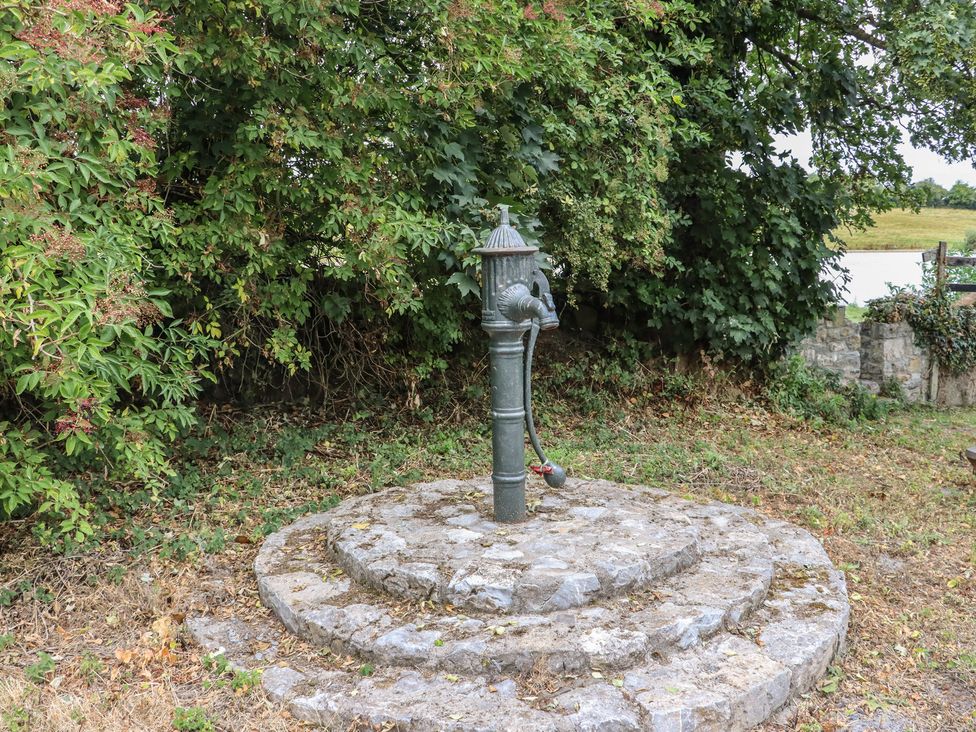 A water pump on a stone base in a garden at The Dairy in Ardfinnan, County Tipperary