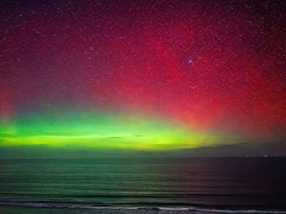 A night sky with aurora borealis over the ocean at Surf and Sand in Carbis Bay