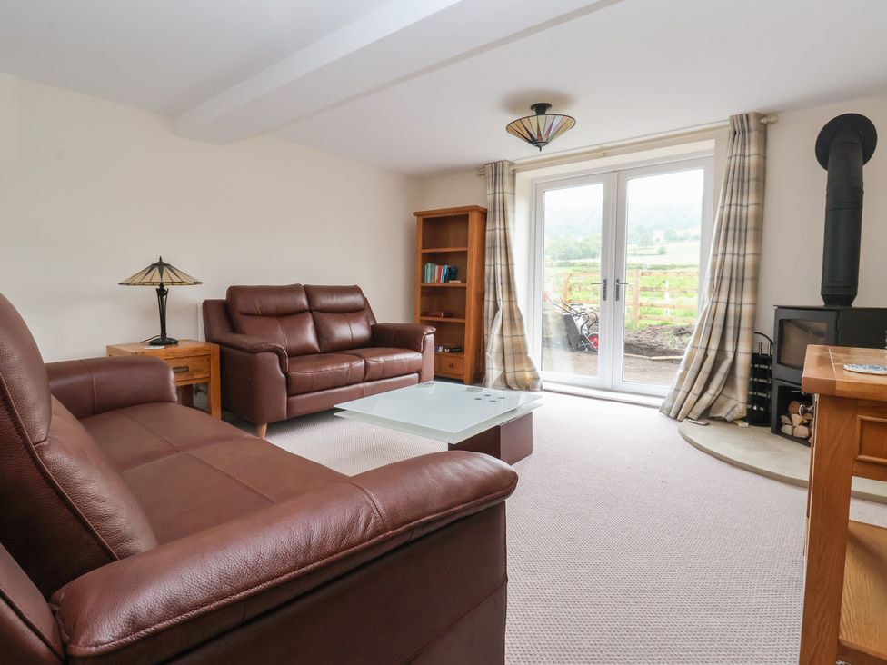 A living room with leather sofas and a coffee table at Cliffe House Cottage