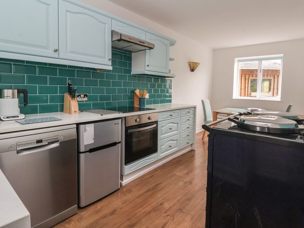 A kitchen with appliances and a dining area at Cliffe House Cottage