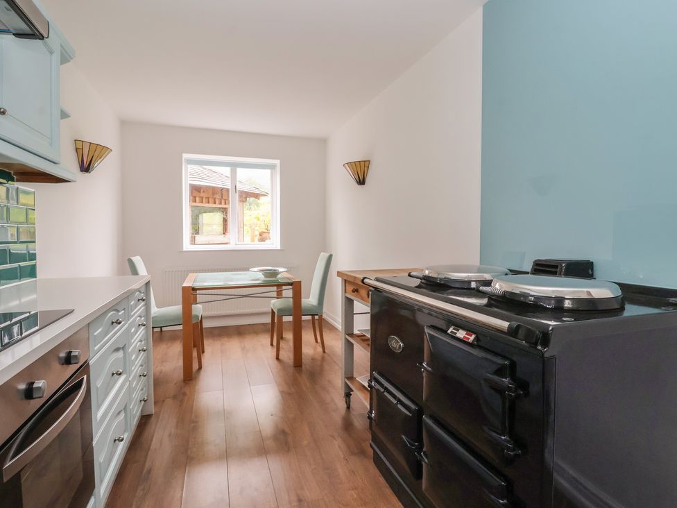 A kitchen with a table and chairs at Cliffe House Cottage