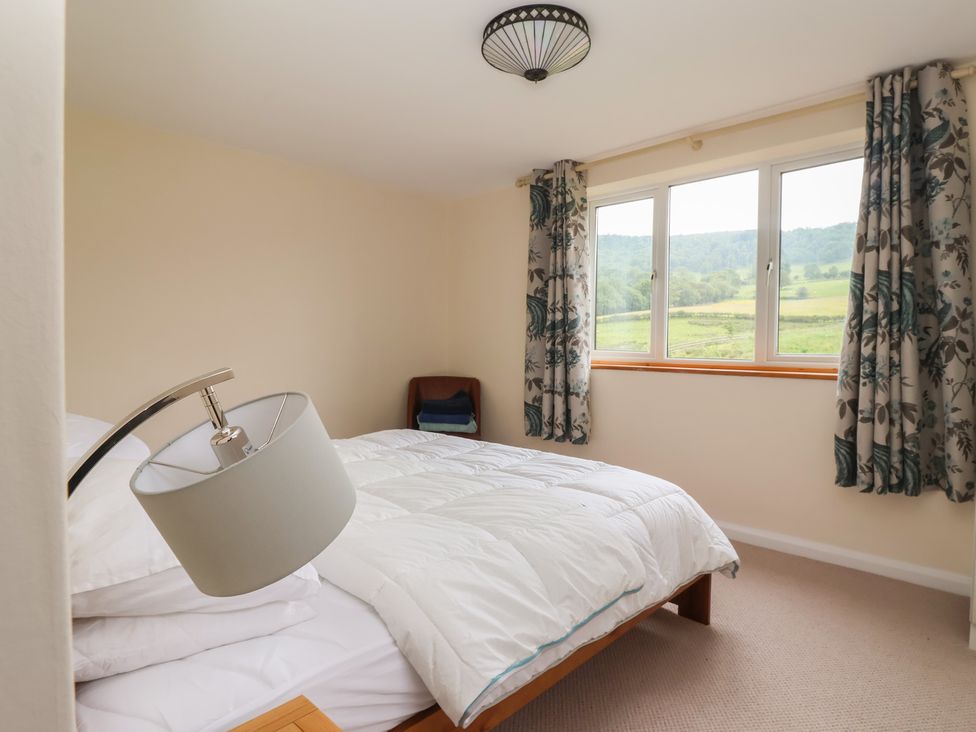 A bedroom with a bed and a window at Cliffe House Cottage