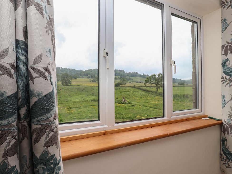 A window with curtains and a view of landscape at Cliffe House Cottage
