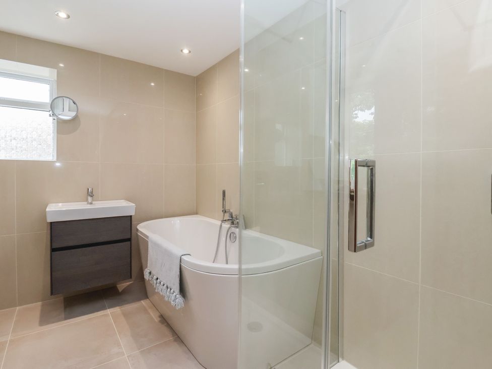 A bathroom with a bathtub and sink at Cliffe House Cottage