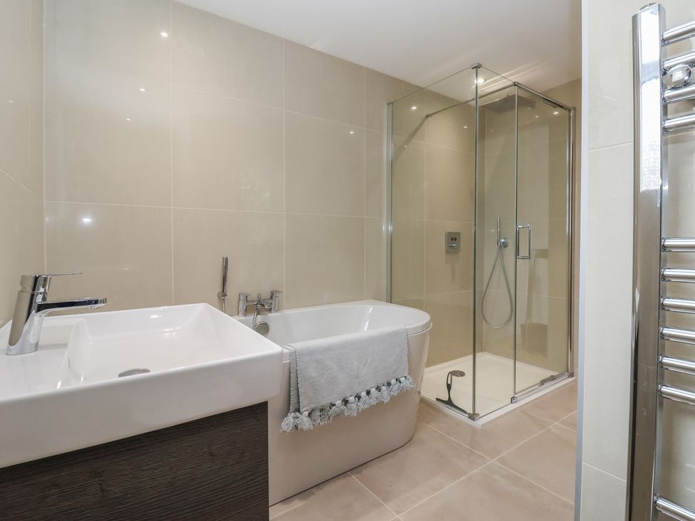 A bathroom featuring a bathtub, sink, and shower at Cliffe House Cottage 