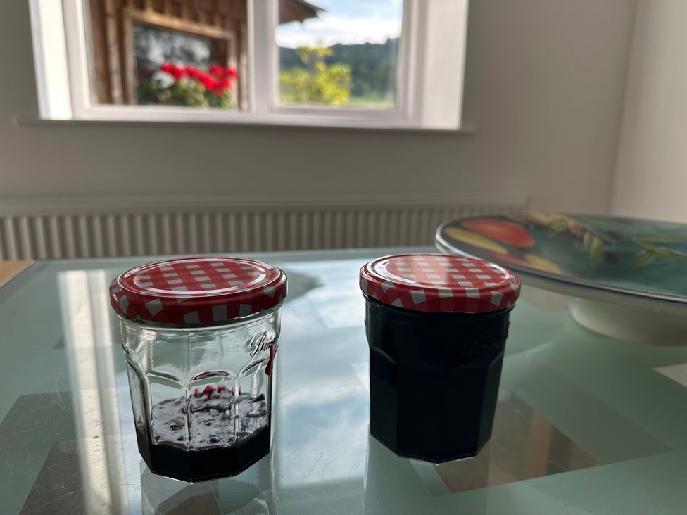 Jam jars on a table near a window at Cliffe House Cottage in Pateley Bridge