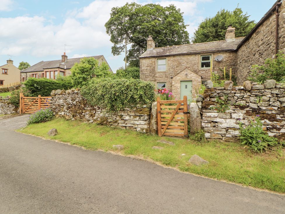 A stone house with a garden and a wooden gate at White House in Shap
