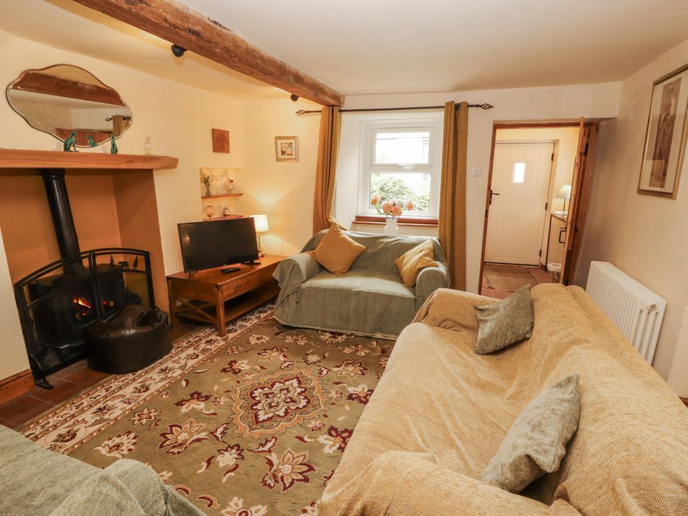 A living room with a fireplace and television at White House in Shap