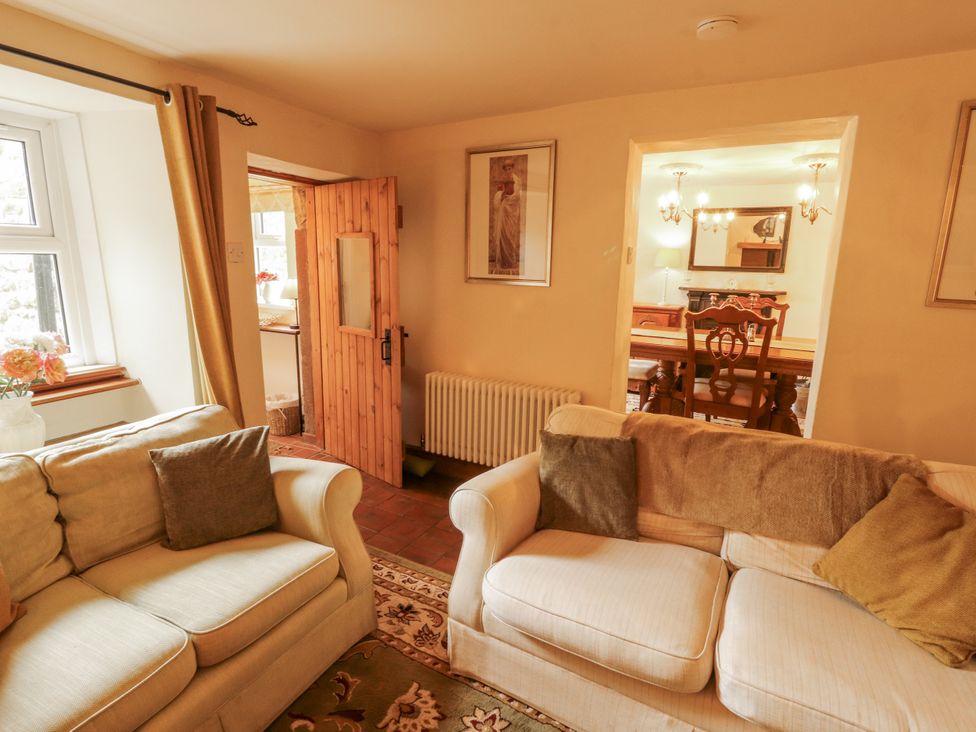 A living room with a sofa and a view of a dining room at White House in Shap