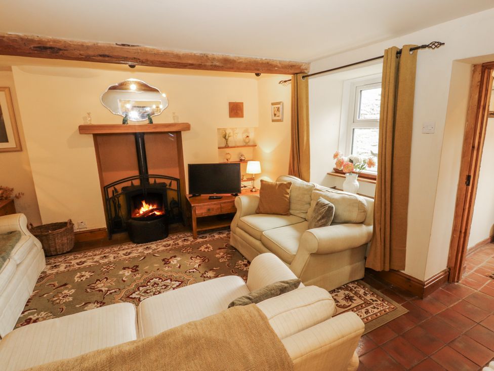 A living room with a fireplace and television at White House in Shap