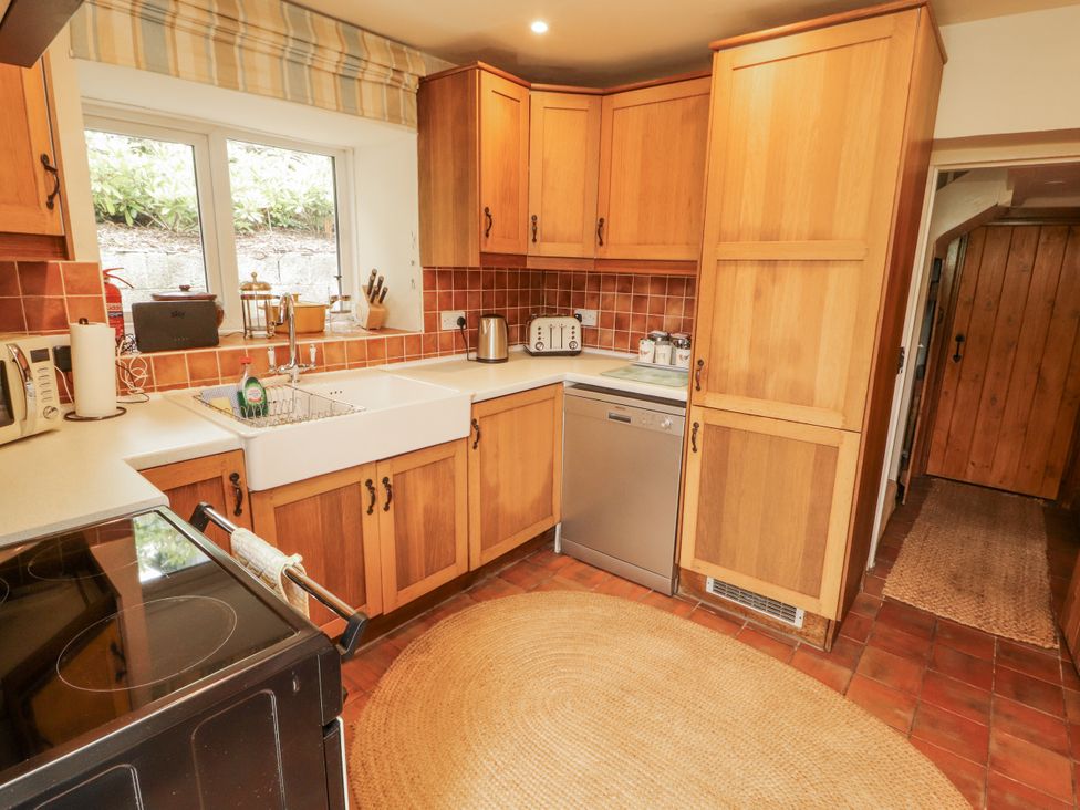 A kitchen with wooden cupboards and appliances at White House in Shap