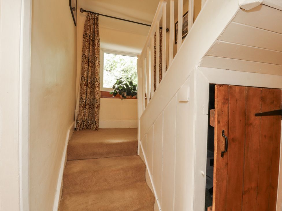 A hallway with stairs leading up and a window at White House in Shap