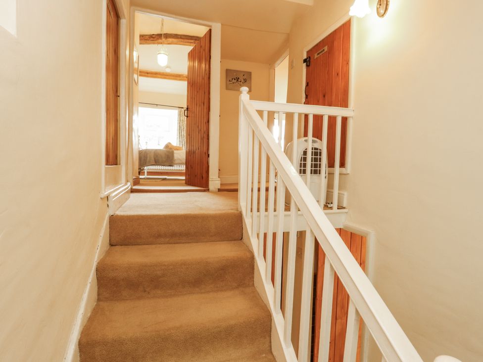 A hallway with stairs and a light fixture at White House in Shap