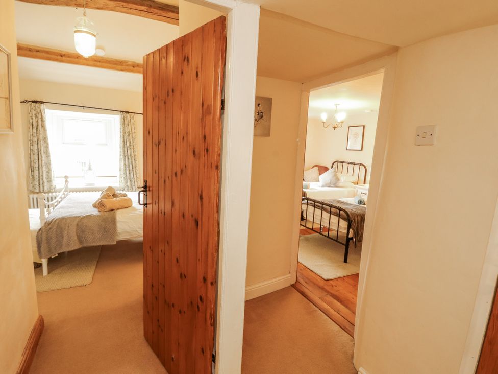 A corridor leading to two bedrooms at White House in Shap