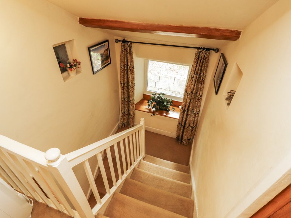 A staircase with a window and pictures at White House in Shap