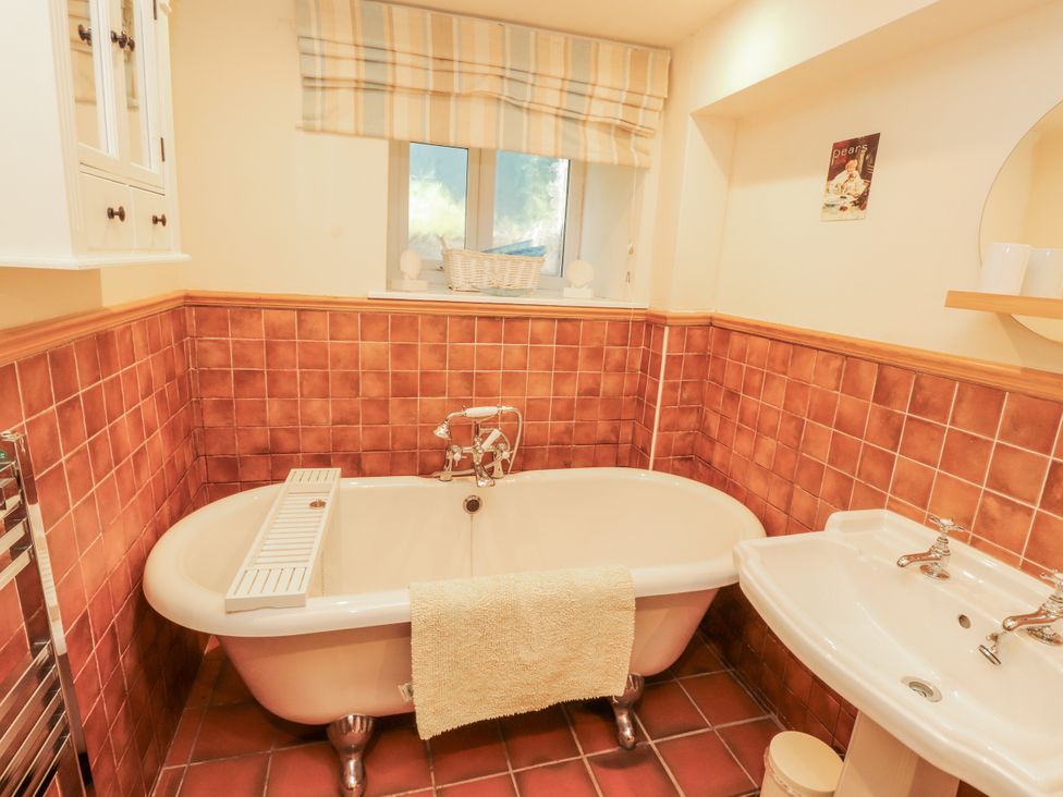 A bathroom with a bathtub and washbasin at the White House in Shap